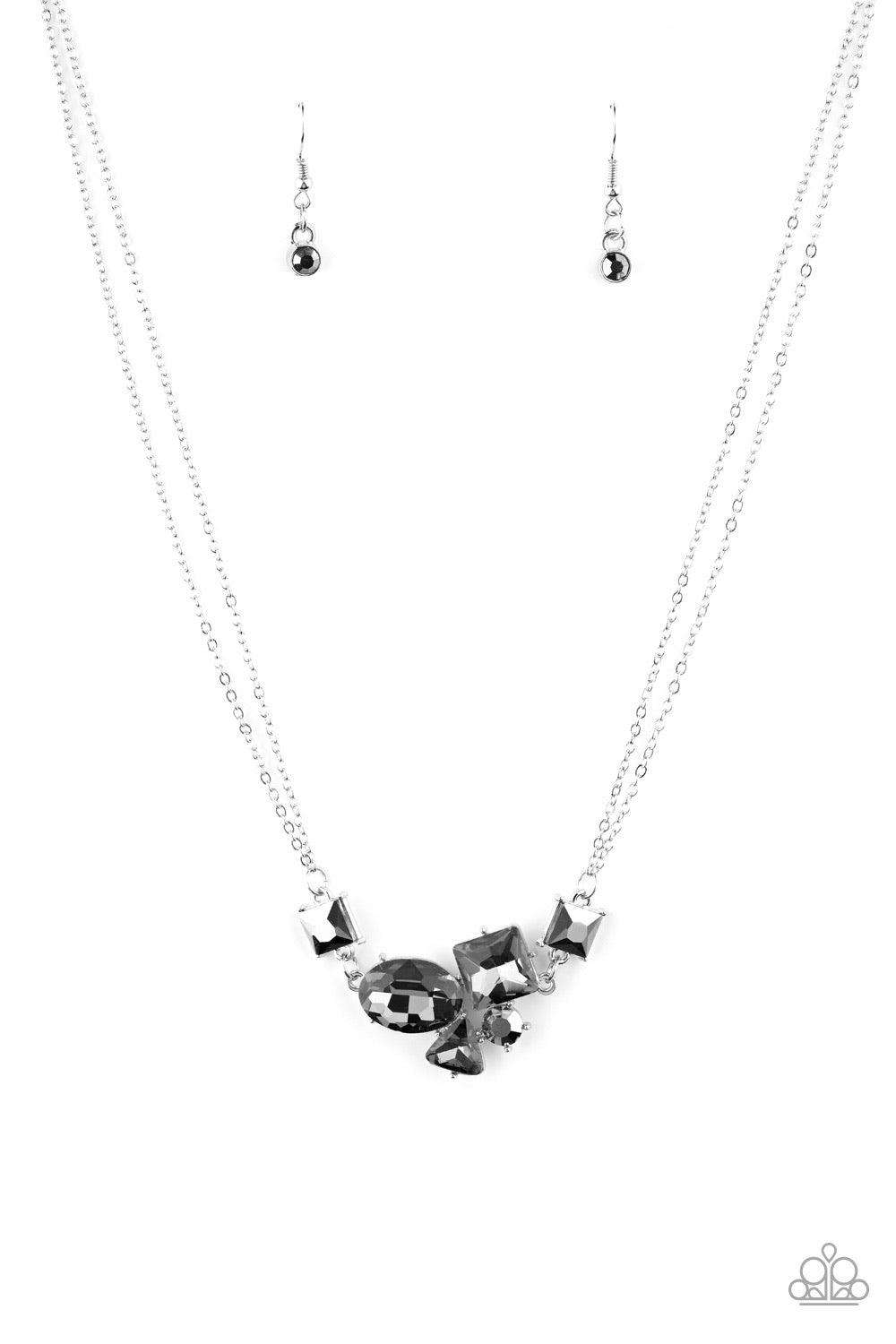 Paparazzi Accessories Constellation Collection - Silver Varying in shape and size, triangular, round, and square cut hematite and smoky rhinestones coalesce into a floating pendant at the bottom of doubled silver chains, creating a stellar shimmer below t