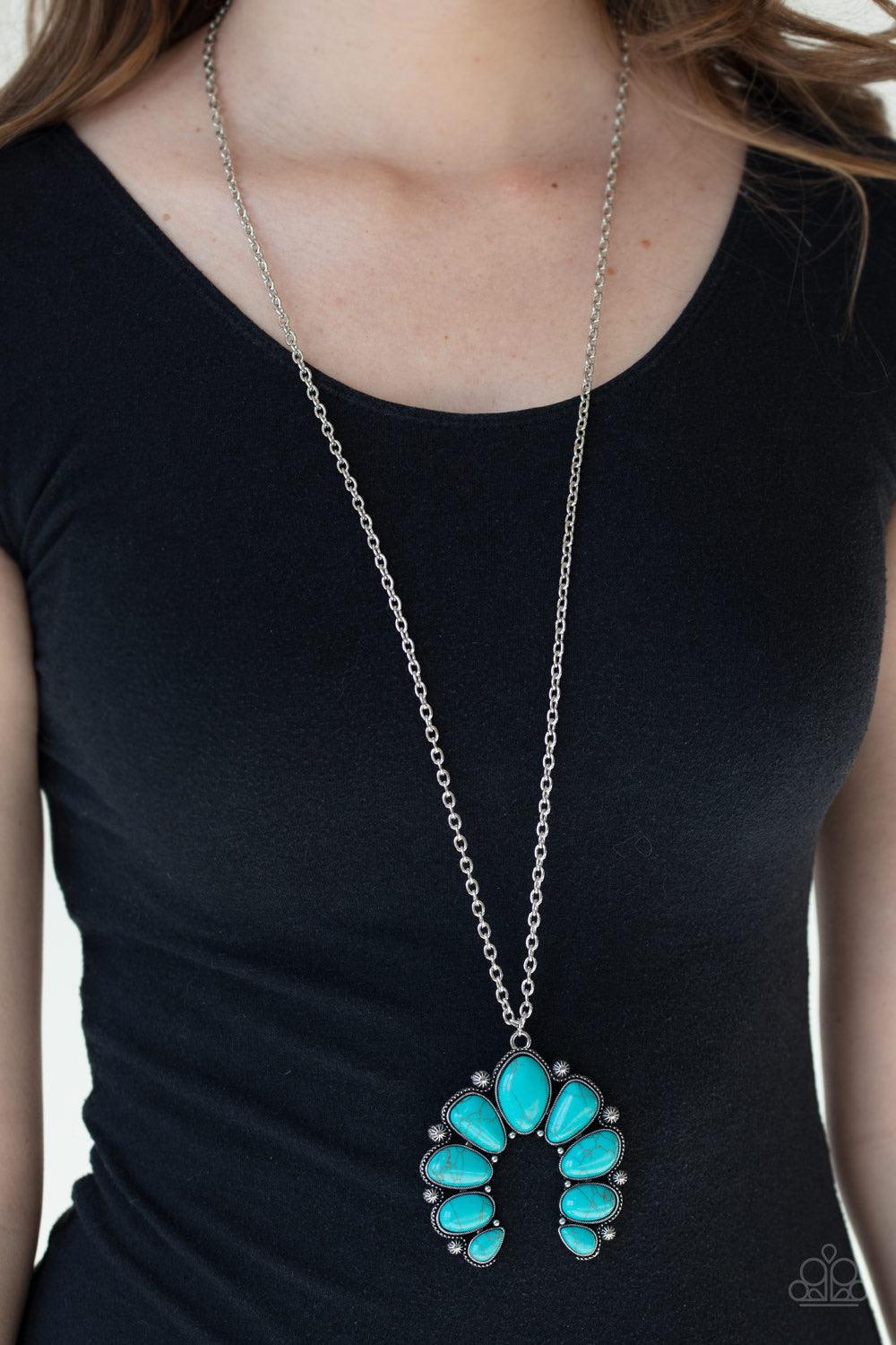 Paparazzi Accessories Stone Monument - Blue Featuring studded silver frames, an asymmetrical collection of refreshing turquoise stones coalesce into an earthy squash blossom pendant at the bottom of a lengthened silver chain. Features an adjustable clasp