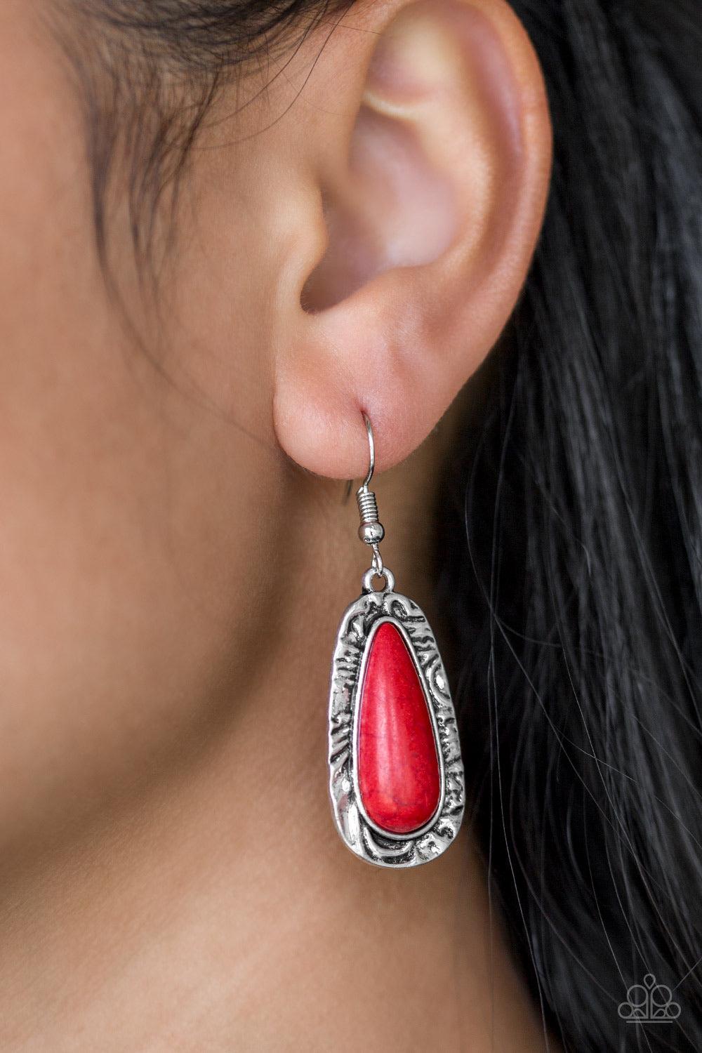 Paparazzi Accessories Cruzin Colorado - Red Chiseled into a tranquil teardrop, a fiery red stone is pressed into the center of a shimmery silver frame radiating with hammered details for an artisan inspired look. Earring attaches to a standard fishhook fi