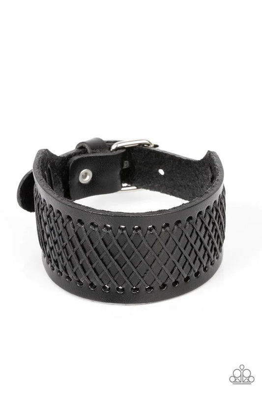 Paparazzi Accessories Drifter Discovery - Black Shiny black cording boldly crisscrosses across the front of a thick black leather band, creating an edgy centerpiece around the wrist. Features a buckle closure. Jewelry