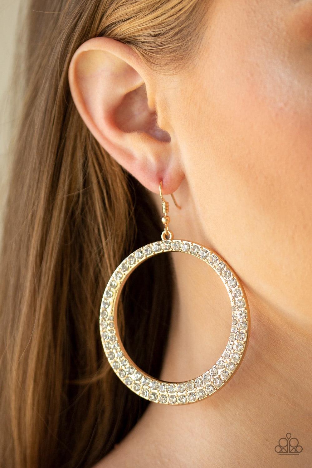 Paparazzi Accessories So Demanding - Gold An oversized gold hoop is encrusted in glittery white rhinestones for a blinding shimmer. Earring attaches to a standard fishhook fitting. Jewelry
