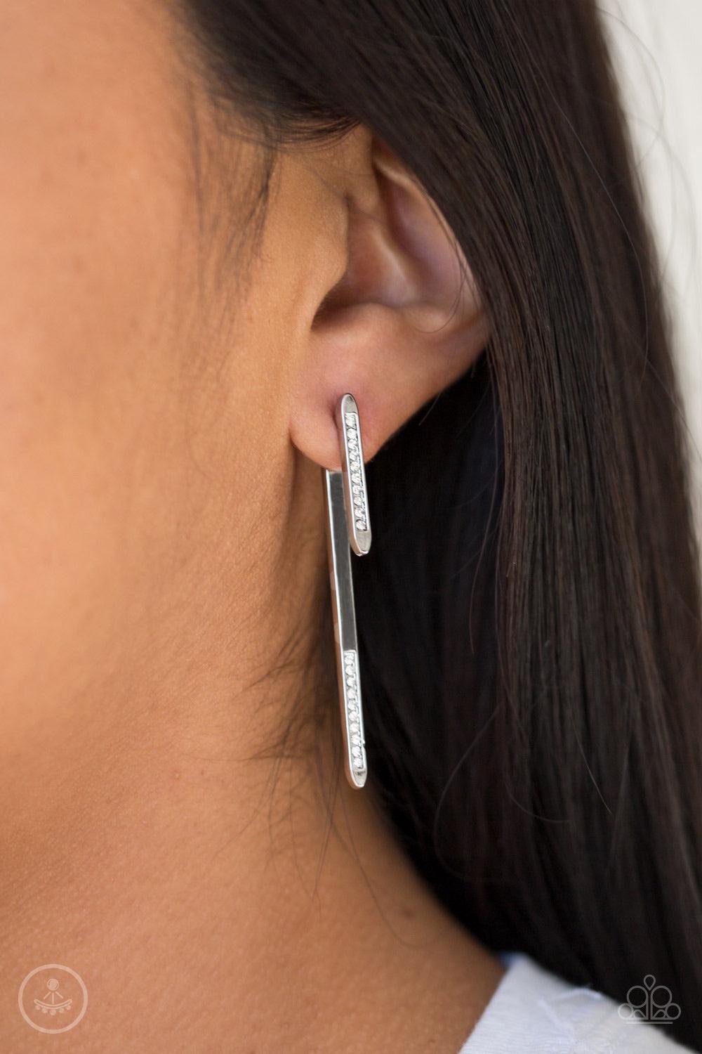 Paparazzi Accessories Very Important VIXEN - White Encrusted in glassy white rhinestones, a dainty silver rod attaches to a double-sided post, designed to fasten behind the ear. As if dipped in white rhinestones, a larger silver rod peeks out beneath the