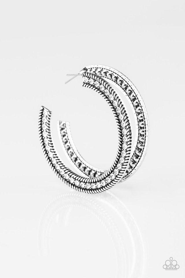 Paparazzi Accessories HAUTE Mama - White Glittery white rhinestones are encrusted along the front of a textured silver hoop for a sassy finish. Earring attaches to a standard post fitting. Hoop measures 2 1/4" in diameter. Sold as one pair of hoop earring