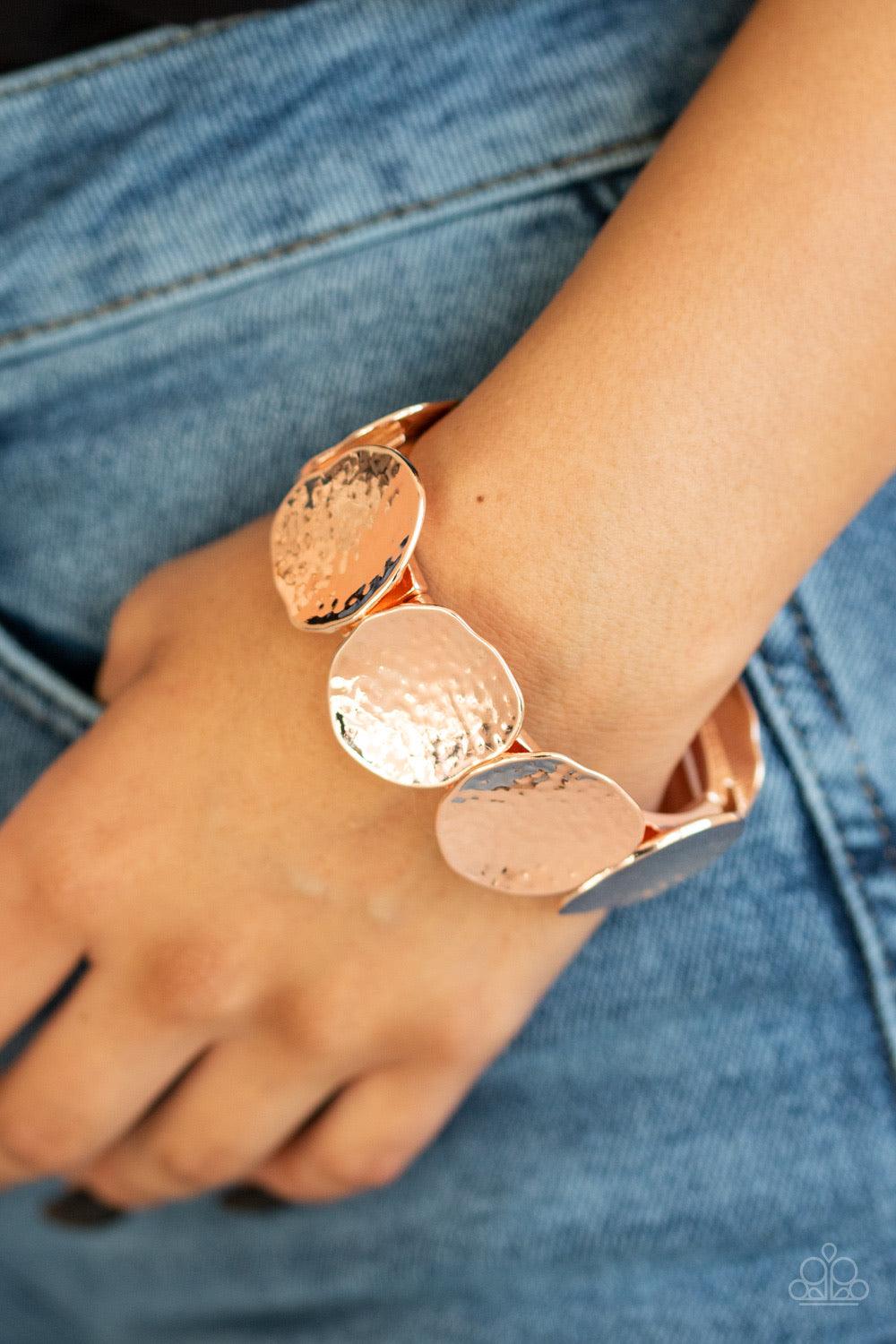 Paparazzi Accessories Treasure Cache - Gold Delicately hammered in shimmer, asymmetrical rose gold discs are threaded along a stretchy band around the wrist for an edgy look. Jewelry