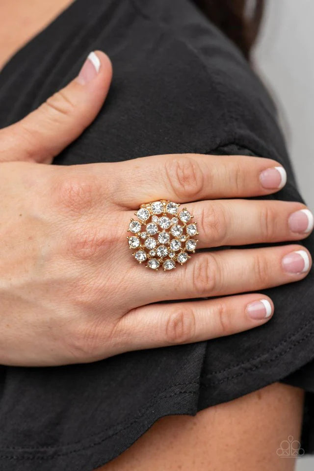 Paparazzi Accessories SELFIE-Confidence - Gold Featuring pronged gold fittings, an explosion of glassy white rhinestones sparkles atop the finger for a statement-making fashion. Features a stretchy band for a flexible fit. Sold as one individual ring. Jew