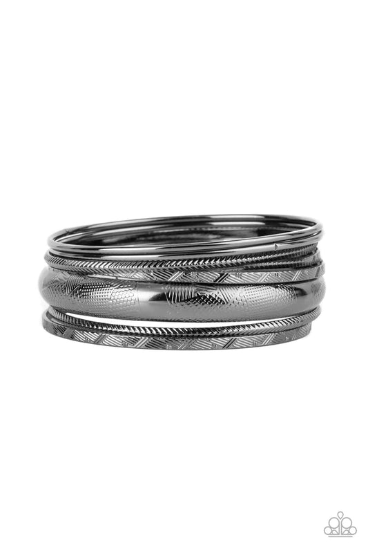 Paparazzi Accessories Stackable Stunner - Black A jangling symphony of classic gunmetal bangles featuring shiny and textured finishes and varying sizes stack up the wrist for a layered look. Sold as one set of seven bracelets. Jewelry