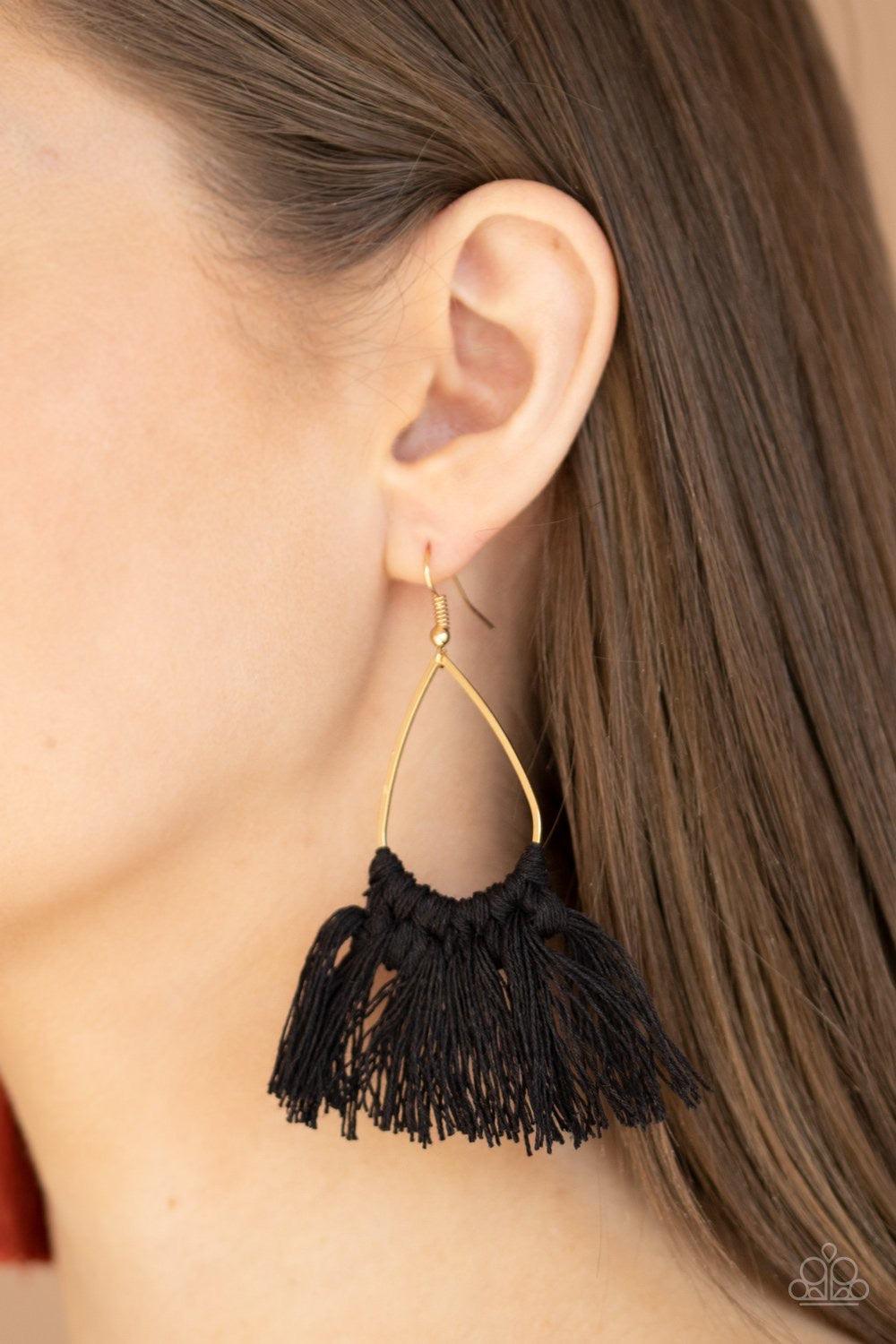 Paparazzi Accessories Tassel Treat - Black Black threaded tassels knot around the bottom of a shimmery gold teardrop frame, creating a flirty fringe. Earring attaches to a standard fishhook fitting. Jewelry