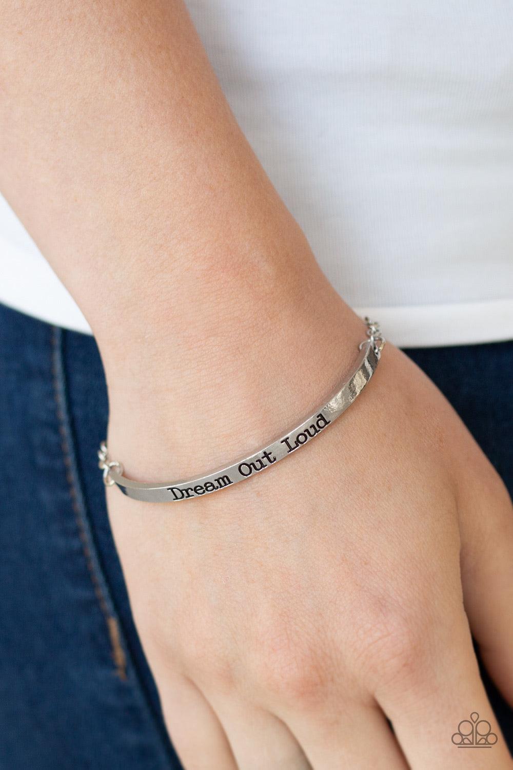 Paparazzi Accessories Dream Out Loud - Silver A glistening silver chain attaches to a dainty silver bar stamped in the inspirational phrase, "Dream Out Loud", for a dreamy finish. Features an adjustable clasp closure. Jewelry