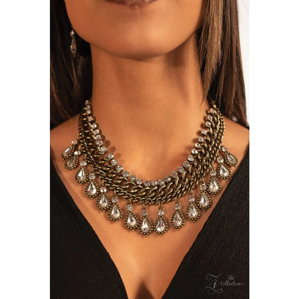 Paparazzi Accessories Revolution A row of dainty classic white rhinestones gives way to rows of thick brass chains. A fringe of sparkling rhinestone teardrops encased in textured frames dances along the bottom of the chains, adding uncompromising shimmer