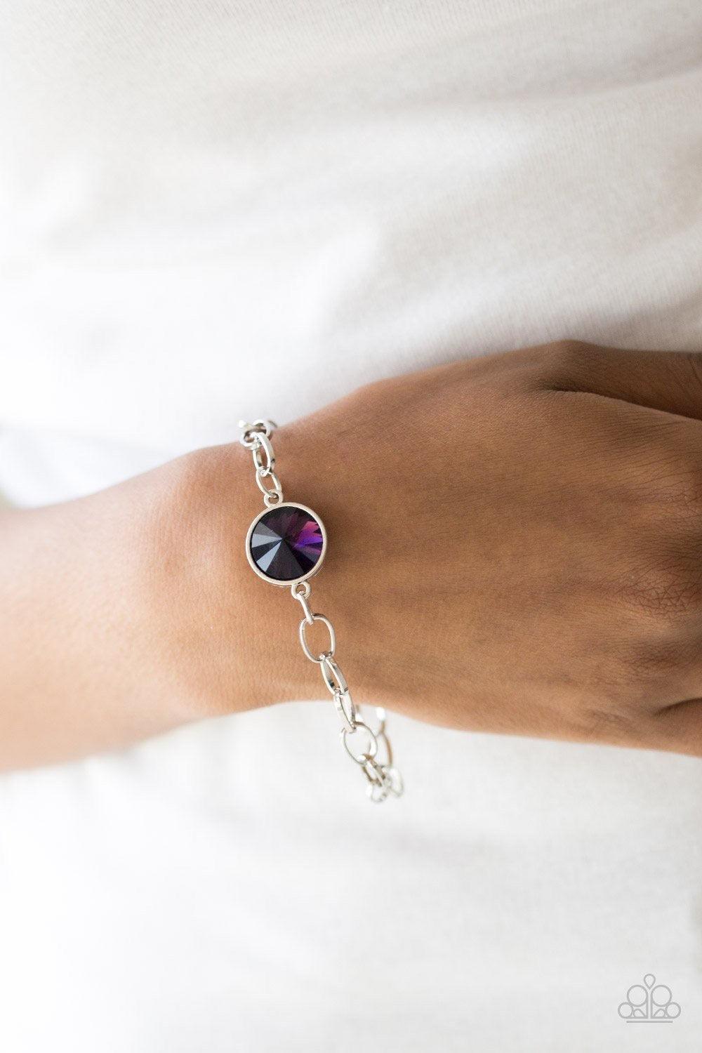 Paparazzi Accessories All Aglitter - Purple A dramatic purple gem attaches to a shiny silver chain, creating a blinding centerpiece atop the wrist. Features a toggle closure. Jewelry