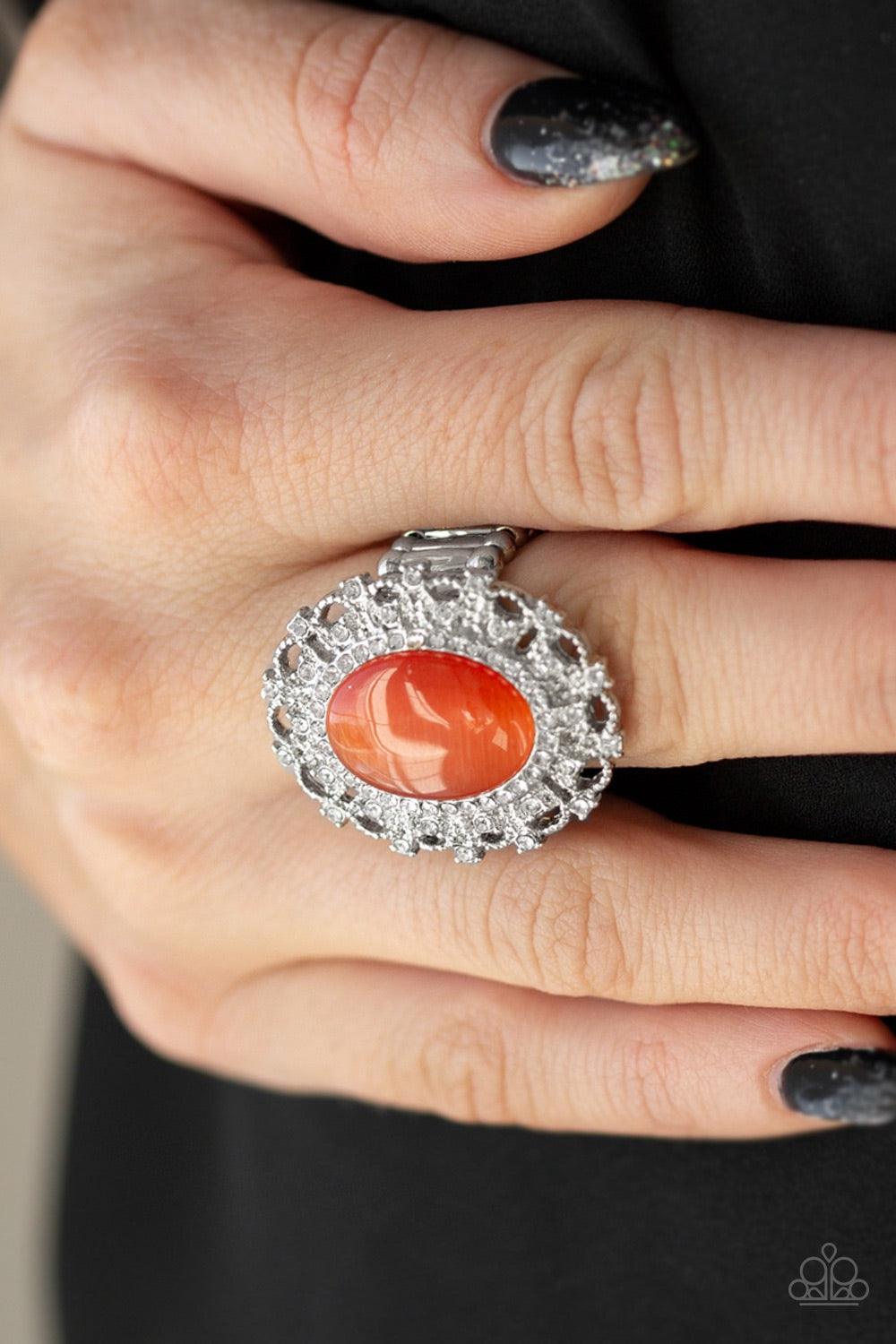 Paparazzi Accessories BAROQUE The Spell - Orange Encrusted in dainty white rhinestones, a frilly silver frame spins around a glowing orange moonstone center for a regal look. Features a stretchy band for a flexible fit. Jewelry