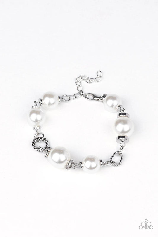 Paparazzi Accessories Boardroom Baller - White A classic collection of white pearls, white rhinestone encrusted rings, and ornate silver accents link across the wrist for a timeless look. Features an adjustable clasp closure.Sold as one individual bracele