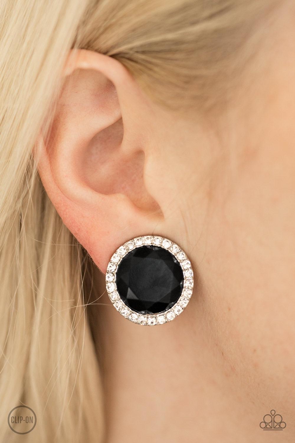 Paparazzi Accessories Positively Princess ~Black *Clip-On A glassy black gem is pressed into the center of a white rhinestone encrusted frame for a timeless look. Earring attaches to a standard clip-on fitting.
