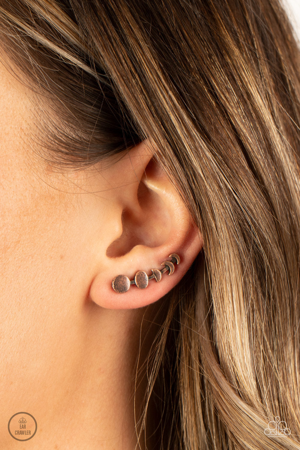 Paparazzi Accessories It’s Just a Phase - Copper A dainty copper bar displays the phases of the moon as it curls across the ear for a stellar look. Features an extended post fitting that climbs the back of the ear and can be pressed together for a more se