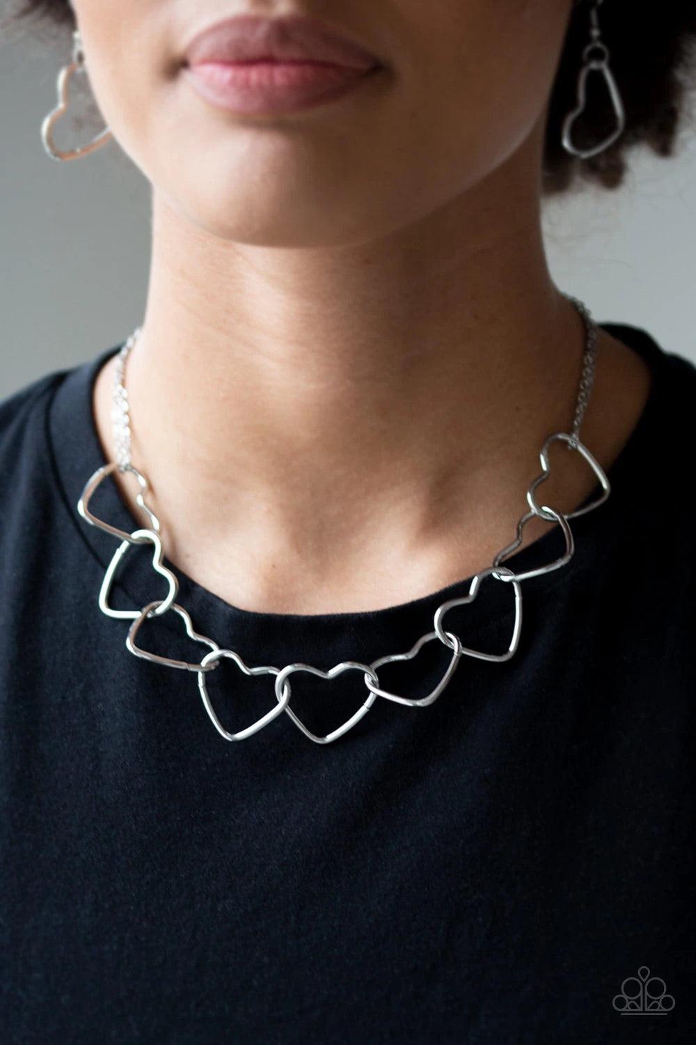 Paparazzi Accessories Unbreak My Heart - Silver Airy silver heart silhouettes connect below the collar for a flirtatious look. Features an adjustable clasp closure. Sold as one individual necklace. Includes one pair of matching earrings. Jewelry