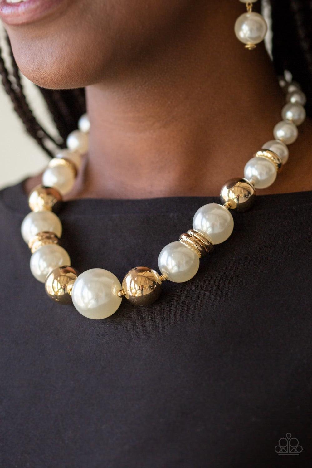 Paparazzi Accessories New York Nightlife - Gold Gradually increasing in size toward the center, dramatic white pearls and shiny gold beads drape below the collar for a refined look. Glistening gold accents are sprinkled between the classic beads, adding d