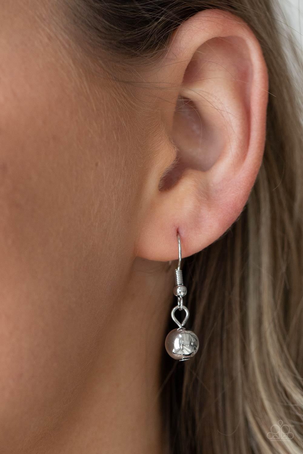 Paparazzi Accessories Beaded Beacon - Silver Brushed in a shiny shimmer, dainty and classic silver beads alternate across the chest in three gleaming layers. The tiered display attaches to oblong and classic silver beads that connect to a silver chain for