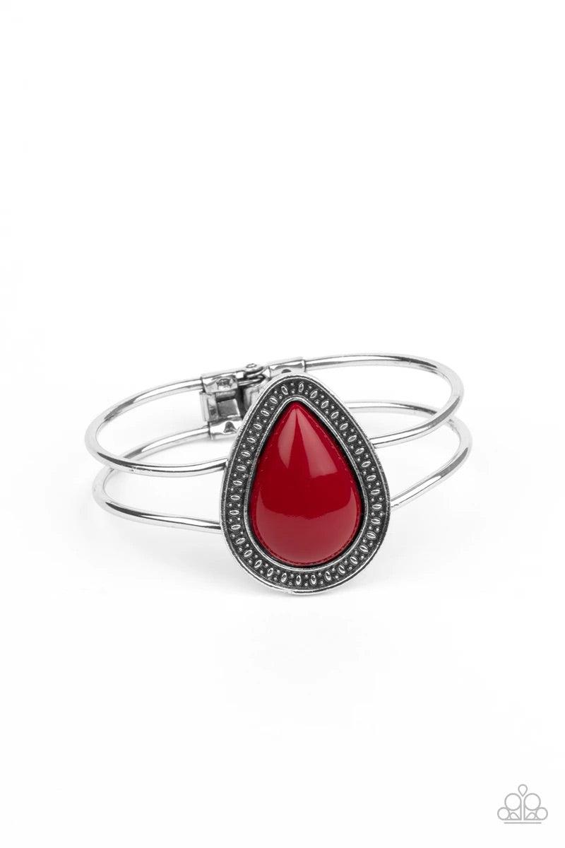Paparazzi Accessories Over The Top Pop - Red A shiny red teardrop bead is pressed into the center of a studded silver frame atop an airy silver cuff, creating a vibrant pop of color around the wrist. Features a hinged closure. Sold as one individual brace