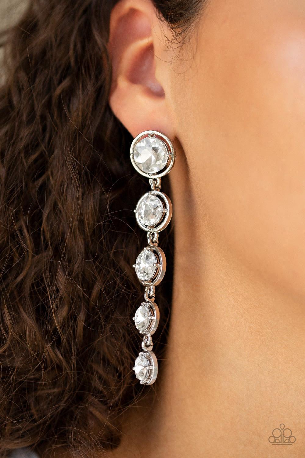 Paparazzi Accessories Drippin In Starlight - White Featuring sleek silver fittings, faceted white gems gradually decrease as they trickle from the ear for a glamorous look. Earring attaches to a standard post fitting. Jewelry