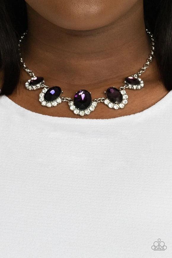 Paparazzi Accessories The Queen Demands It - Purple Gradually increasing in size at the center, the sparkly bottoms of oversized purple gems are bordered in rows of glassy white rhinestones as they link below the collar for a dramatic effect. Features an