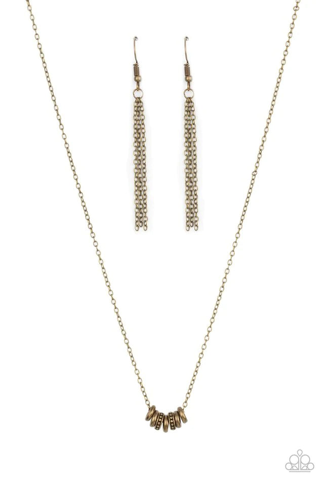 Paparazzi Accessories Dainty Dalliance - Brass An antiqued collection of smooth and studded brass rings glide along a dainty brass chain below the collar, creating a minimalist inspired look. Features an adjustable clasp closure. Sold as one individual ne