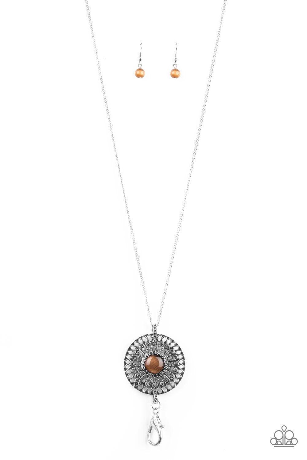 Paparazzi Accessories So Solar - Brown *Lanyard A glowing brown moonstone is pressed into the center of a silver medallion radiating with ornate sunburst textures for a whimsical look. A lobster clasp hangs from the bottom of the design to allow a name ba