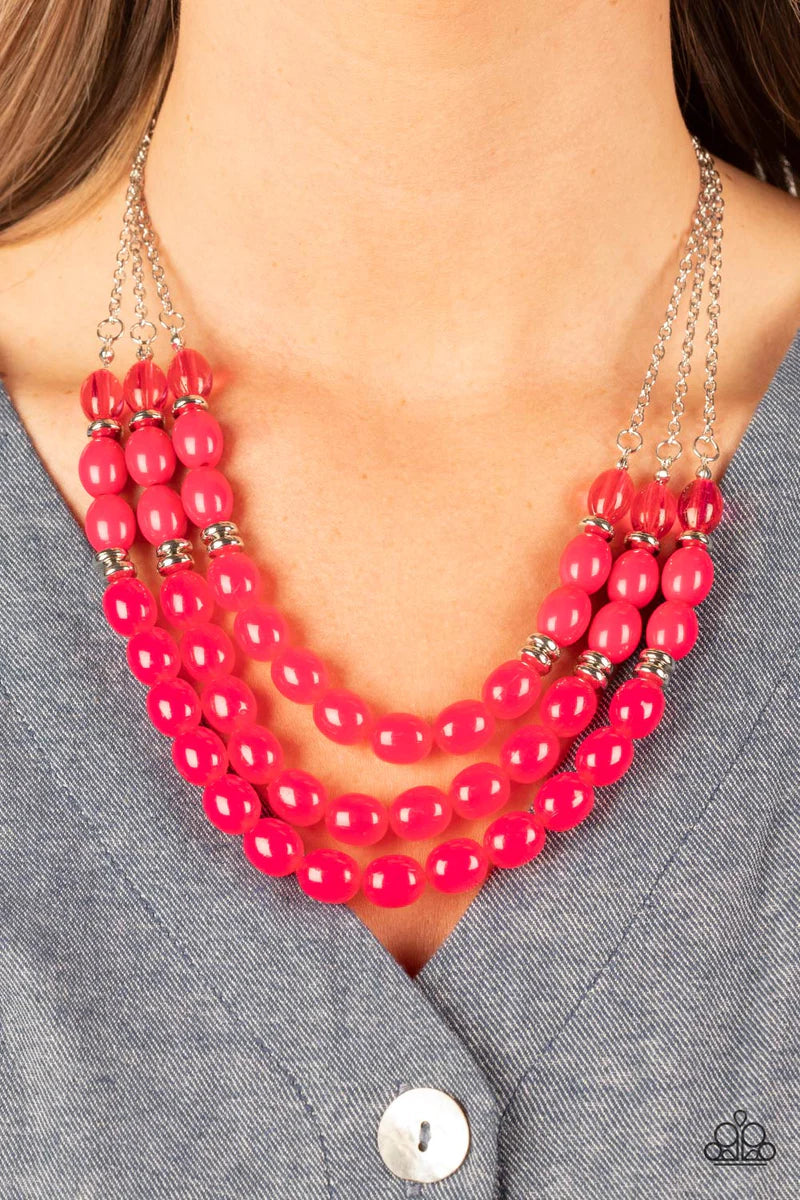 Paparazzi Accessories Coastal Cruise - Pink Infused with silver accents, rows of glassy, opaque, and acrylic Fuchsia Fedora beads are threaded along invisible wires at the bottom of silver chains that layer into a vivacious pop of color below the collar.