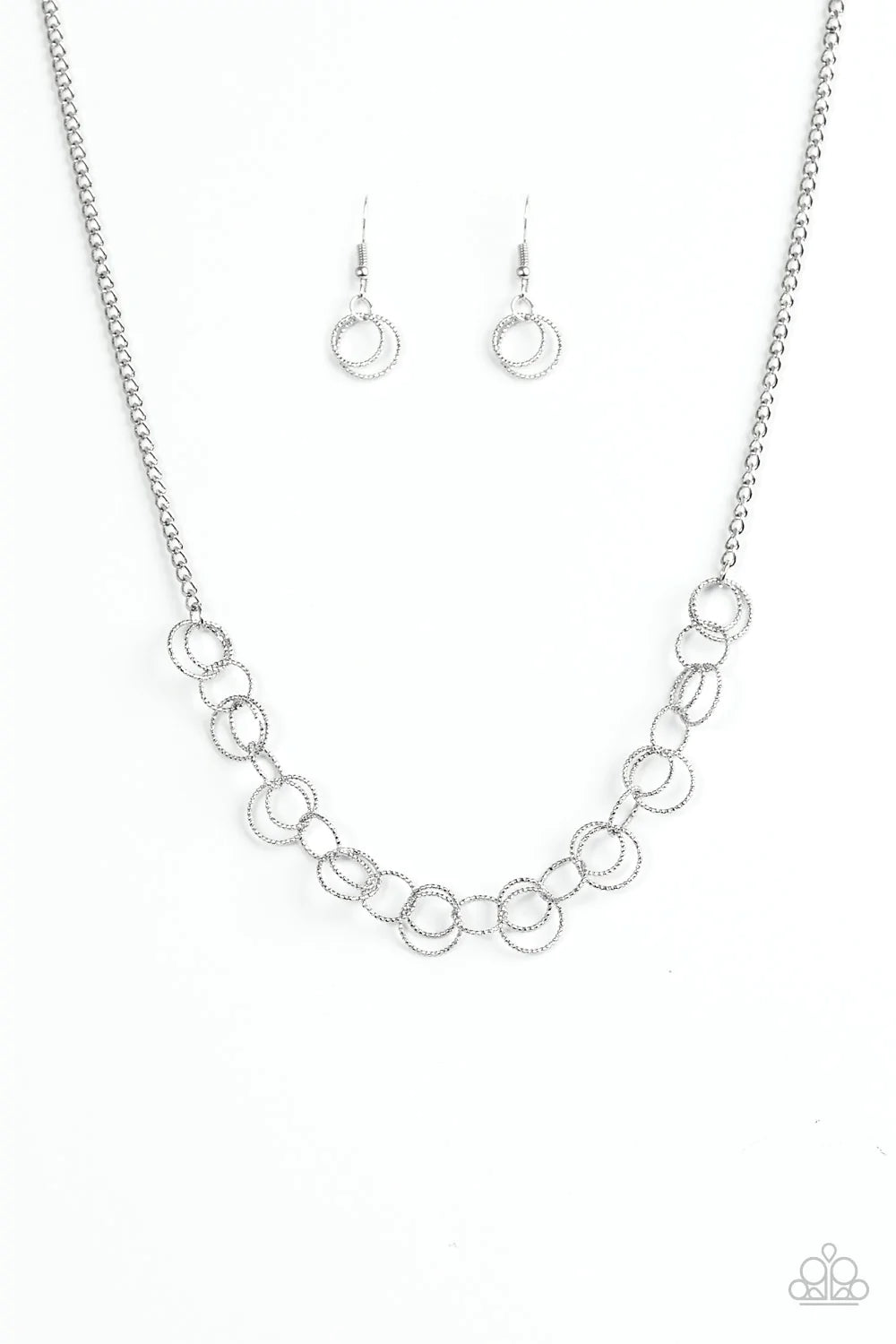 Paparazzi Accessories One RING Leads To Another - Silver Delicately etched in radiant textures, dainty silver rings join below the collar in a dizzying fashion. Features an adjustable clasp closure. Sold as one individual necklace. Includes one pair of ma