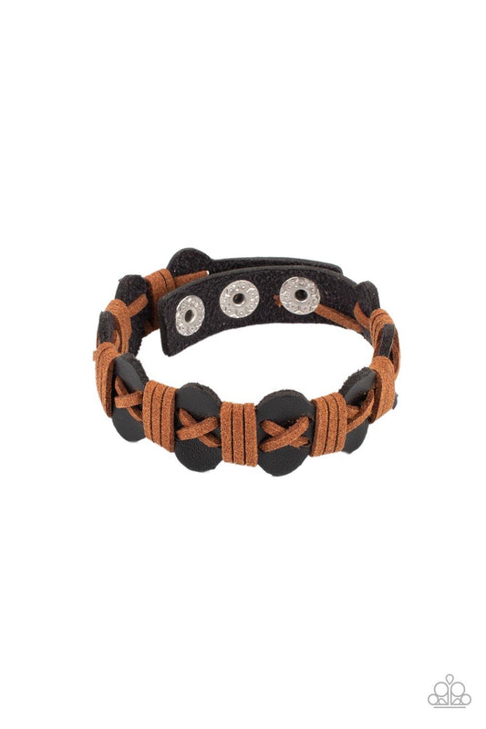 Paparazzi Accessories Macho Maverick - Multi Light brown suede cording is threaded in a crisscross pattern along the front of a wavy brown suede band. Additional brown cording wraps across the scalloped band in intervals creating a rustic handmade look. F