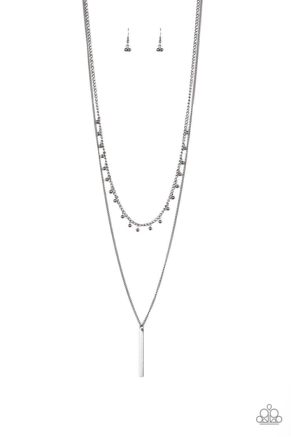 Paparazzi Accessories Keep Your Eye On The Pendulum - Black Two mismatched gunmetal chains layer down the chest. Dainty gunmetal beads dangle from the bottom of the uppermost chain, while a rectangular pendulum-like pendant swings from the lowermost chain