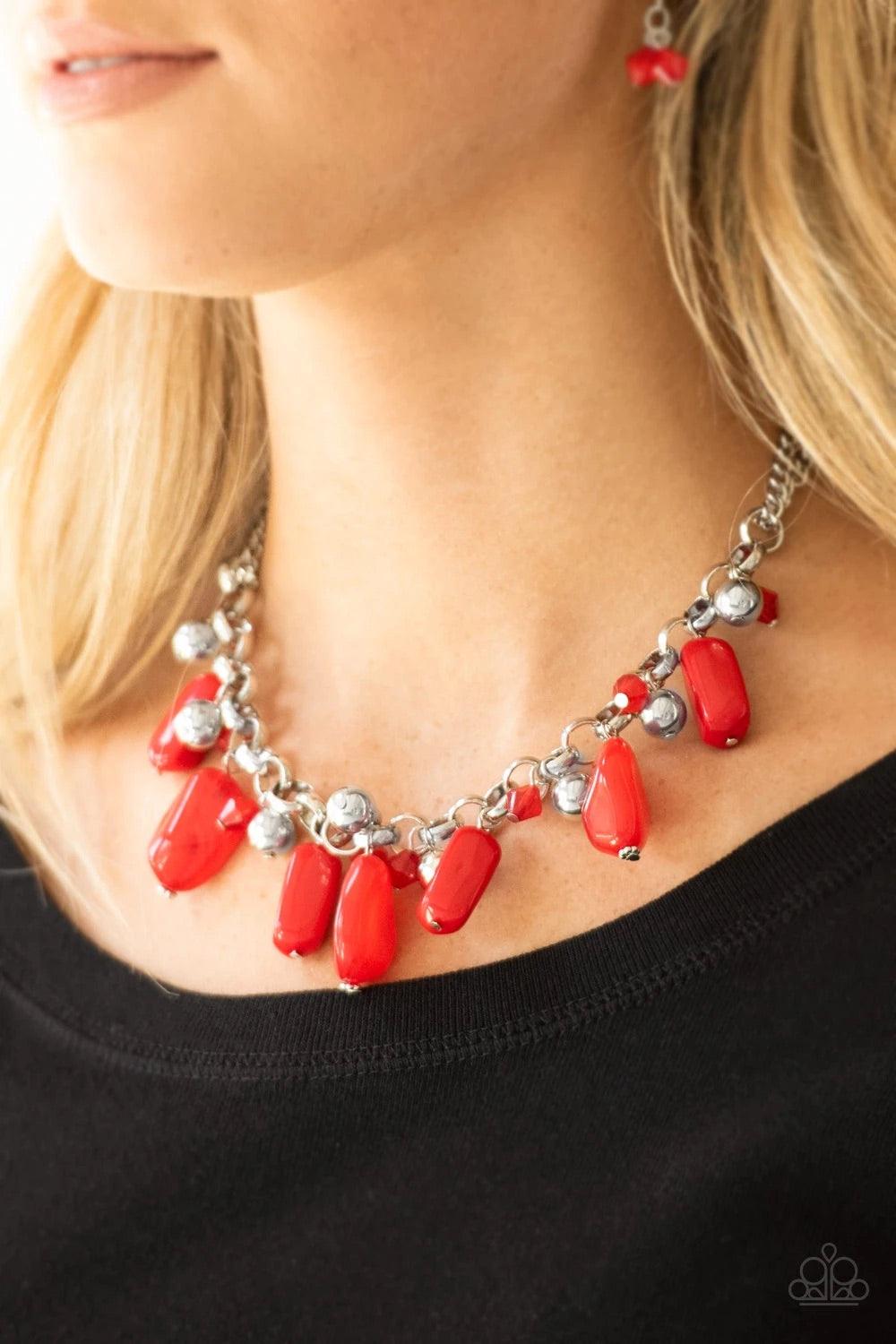 Paparazzi Accessories Grand Canyon Grotto - Red Featuring polished and cloudy finishes, a collection of red faux rocks dance from the bottom of a bold silver chain. Classic silver beads trickle between the colorful beading, adding a metallic shimmer to th