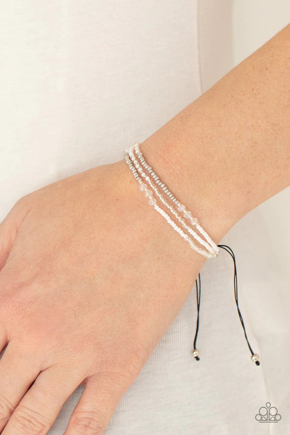 Paparazzi Accessories BEAD Me Up Scotty! - White Three strands of silver and white micro beads accented with sparkling clear multi-faceted beads give off a space-age vibe. Features an adjustable sliding knot closure. Sold as one individual bracelet. Jewel