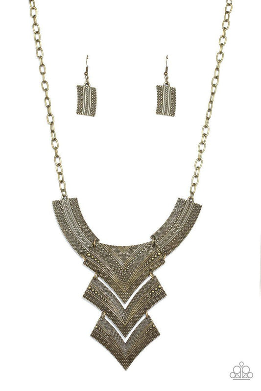 Paparazzi Accessories Fiercely Pharaoh - Brass Radiating in studded details, antiqued brass plates link below the collar, joining into a fierce geometric pendant. Features an adjustable clasp closure.Sold as one individual necklace. Includes one pair of m