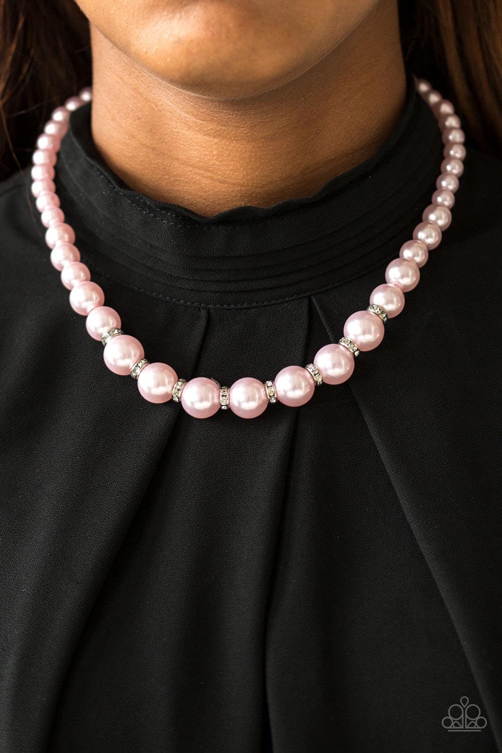 Paparazzi Accessories Showtime Shimmer - Pink Gradually increasing in size near the bottom, classic pink pearls drape below the collar. Rhinestone encrusted rings are sprinkled between the dramatic pearls, adding sparkling accents to the timeless pearl pa