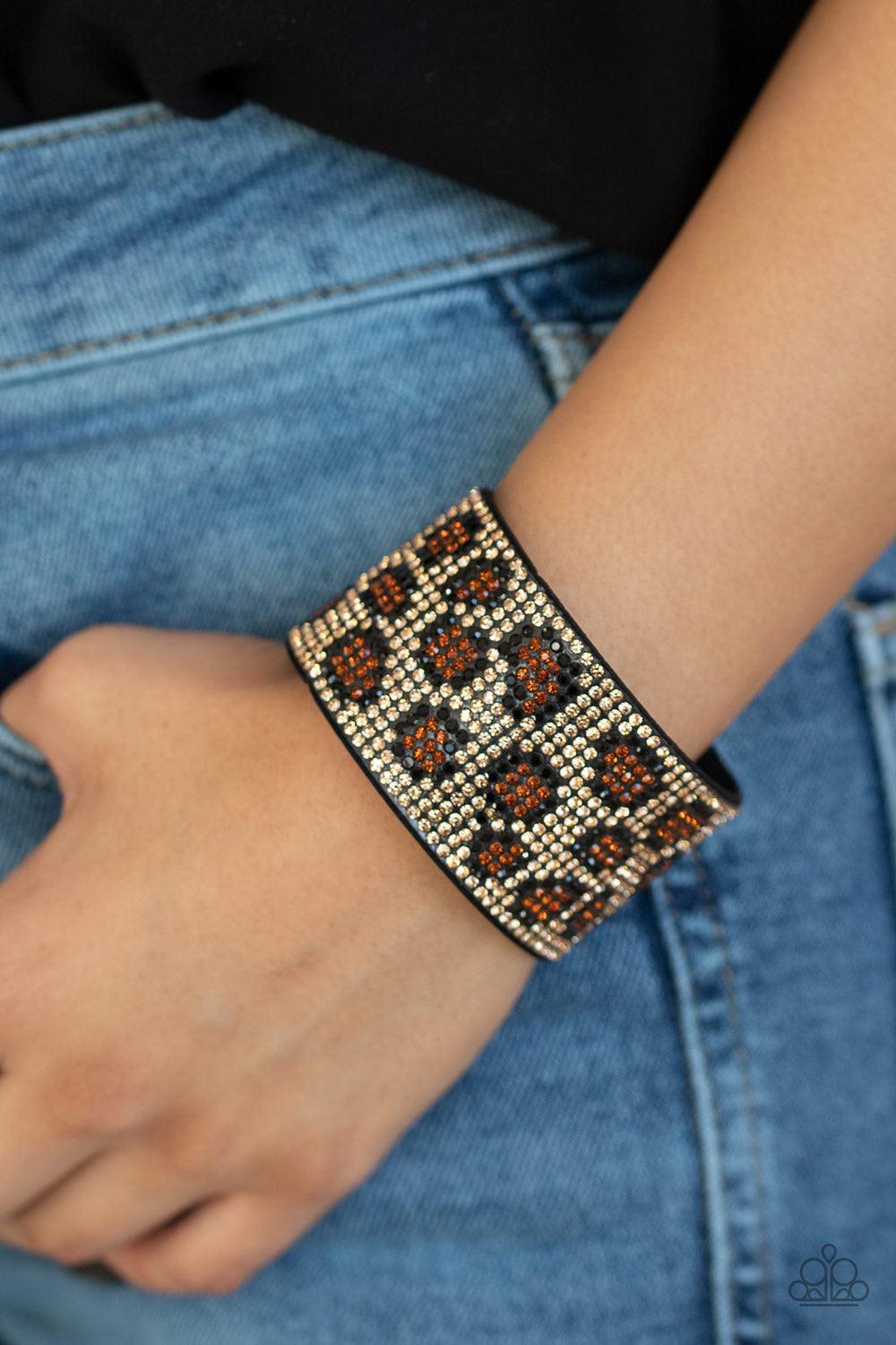 Paparazzi Accessories Cheetah Couture - Brown Row after row of golden brown, black, and topaz rhinestones collect into a dazzling cheetah pattern across the front of a thick black suede band for a wild look. Features an adjustable snap closure. Jewelry