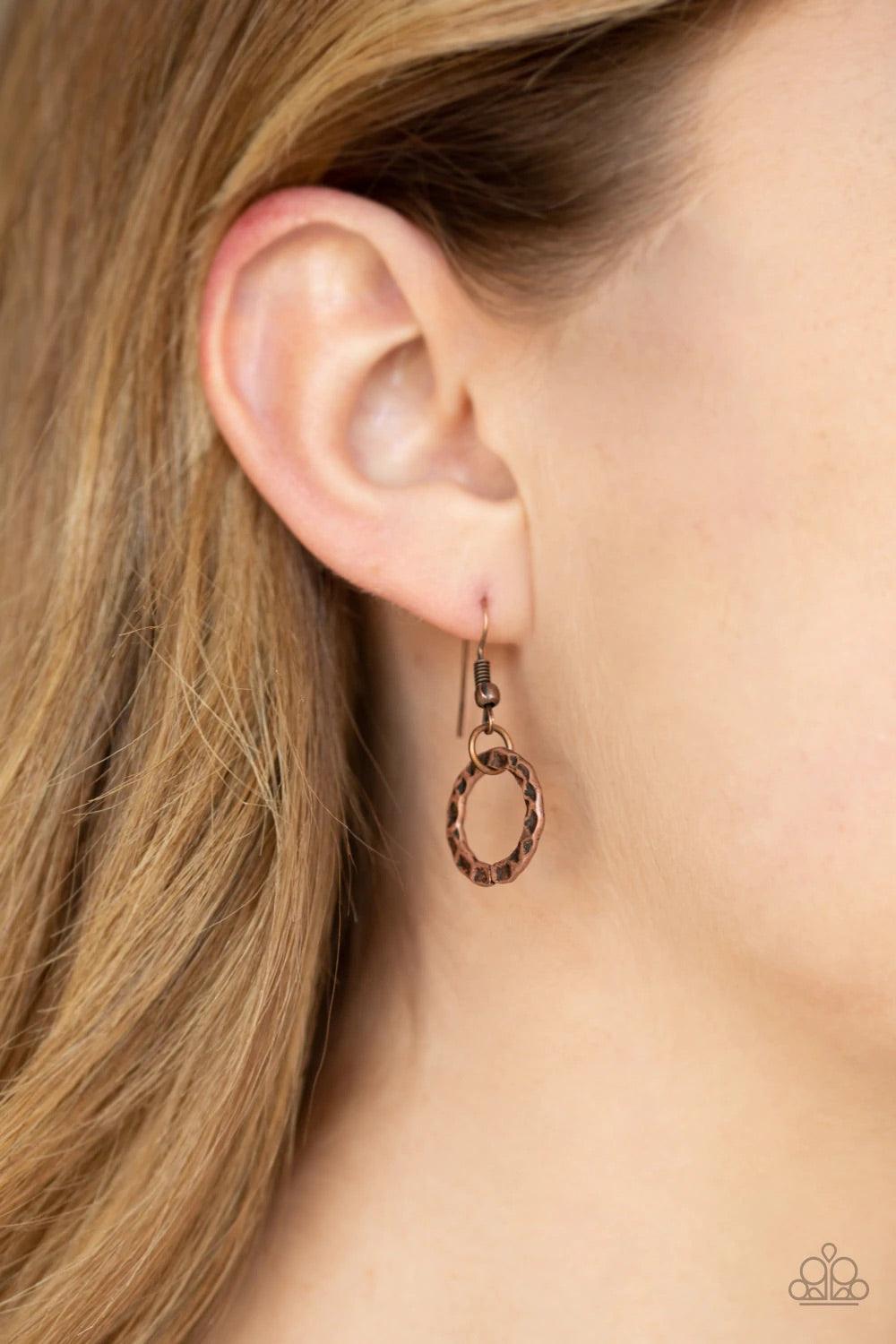 Paparazzi Accessories Metal Marathon - Copper Featuring a hammered finish, a collection of interlocking copper hoops are threaded through the center of textured copper fittings. The dizzying pendant swings from the bottom of a lengthened copper chain for