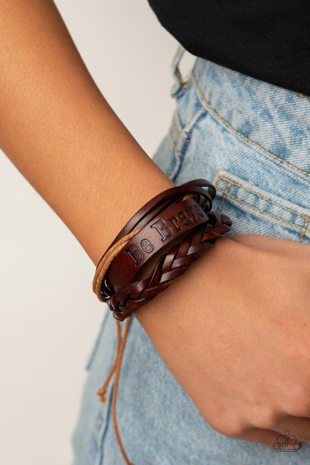 Paparazzi Accessories Brave Soul - Brown Mismatched strands of brown twine and leather cords join a thick brown leather band stamped in the phrase, "Be Brave," around the wrist for a rustically layered look. Features an adjustable sliding knot closure. So