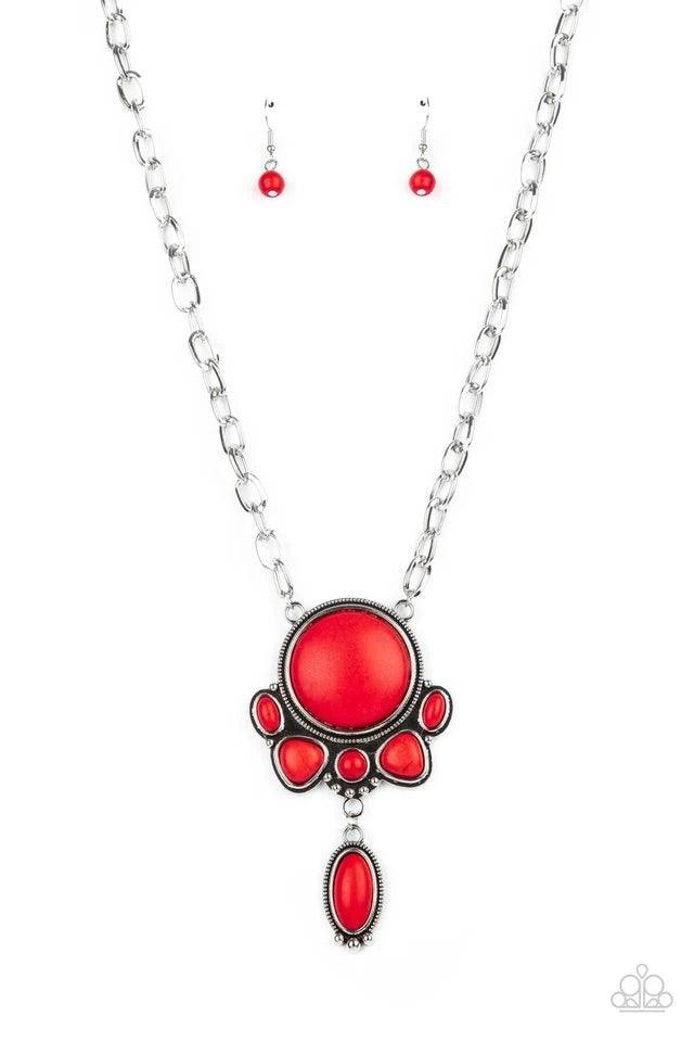 Paparazzi Accessories Geographically Gorgeous - Red A large red stone encased in a studded silver frame swings dramatically from a heavy silver chain with oversized links. A collection of red stones wraps around the bottom of the large pendant, with an el