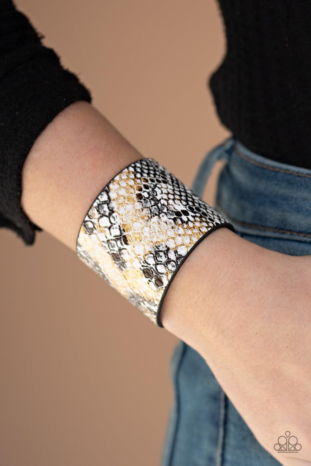 Paparazzi Accessories Serpent Shimmer - Multi Featuring a shiny gold and black python print, a thick white leather band wraps around the wrist for a wild shimmer. Features an adjustable snap closure. Sold as one individual bracelet. Jewelry