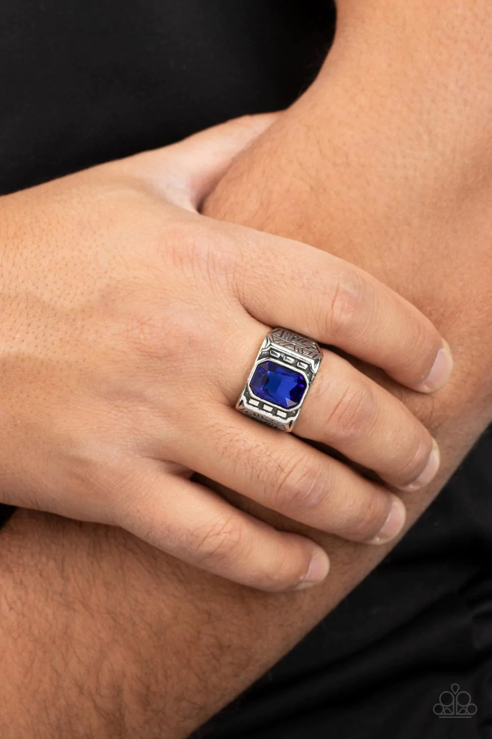 Paparazzi Accessories Metro Magnate - Blue A majestic emerald cut blue rhinestone is pressed into the center of a rectangular studded silver frame flanked by geometric texture, creating an edgy centerpiece atop the finger. Features a stretchy band for a f