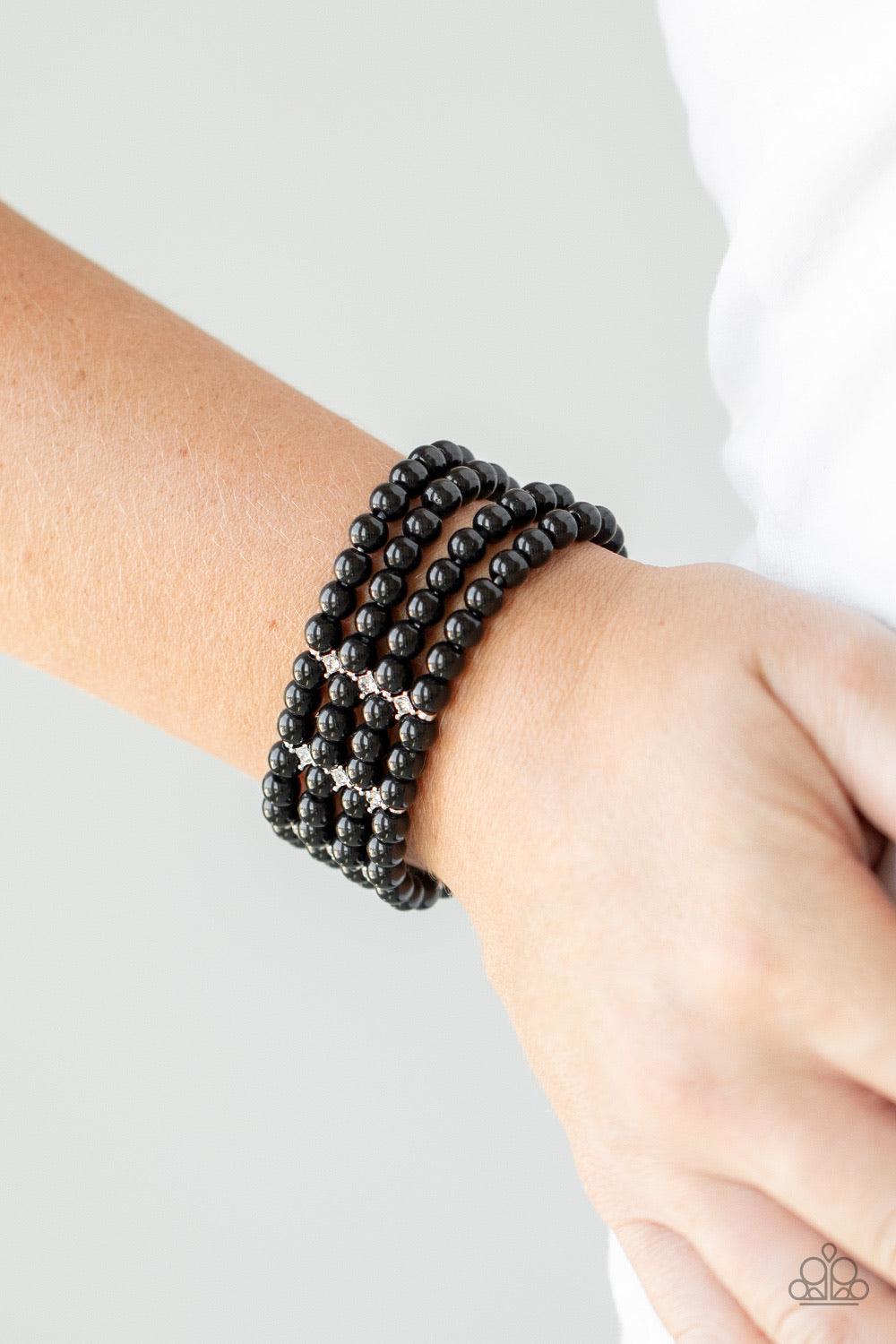 Paparazzi Accessories Stacked To The Top - Black Held together by glittery white rhinestone encrusted silver fittings, row after row of shiny black beads are threaded along stretchy bands around the wrist for a timelessly stacked look. Sold as one individ