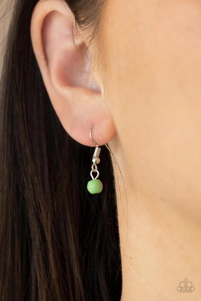 Paparazzi Accessories Sandstone Safari - Green A mismatched collection of brown wooden beads, green pebbles, hammered silver ovals, and dainty green stone beads haphazardly adorn sections of silver chain across the chest, creating an earthy seasonal flair