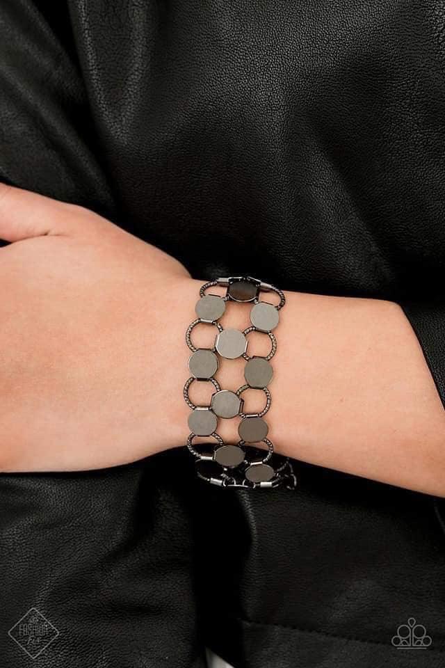 Paparazzi Accessories Cast a Wider Net Dotted with reflective gunmetal discs, an interlocking net of textured gunmetal rings link into edgy netted layers around the wrist. Features an adjustable clasp closure.