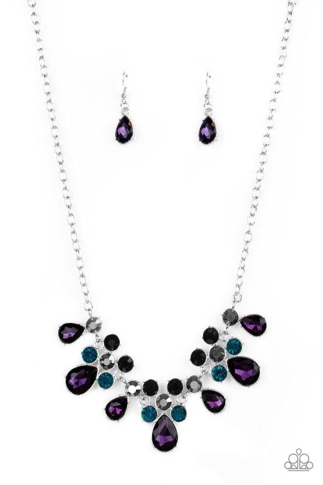 Paparazzi Accessories Debutante Drama - Purple A collection of round and teardrop purple, blue, hematite, and black rhinestones coalesce into dazzling frames as they link below the collar, creating a glamorous fringe. Features an adjustable clasp closure.