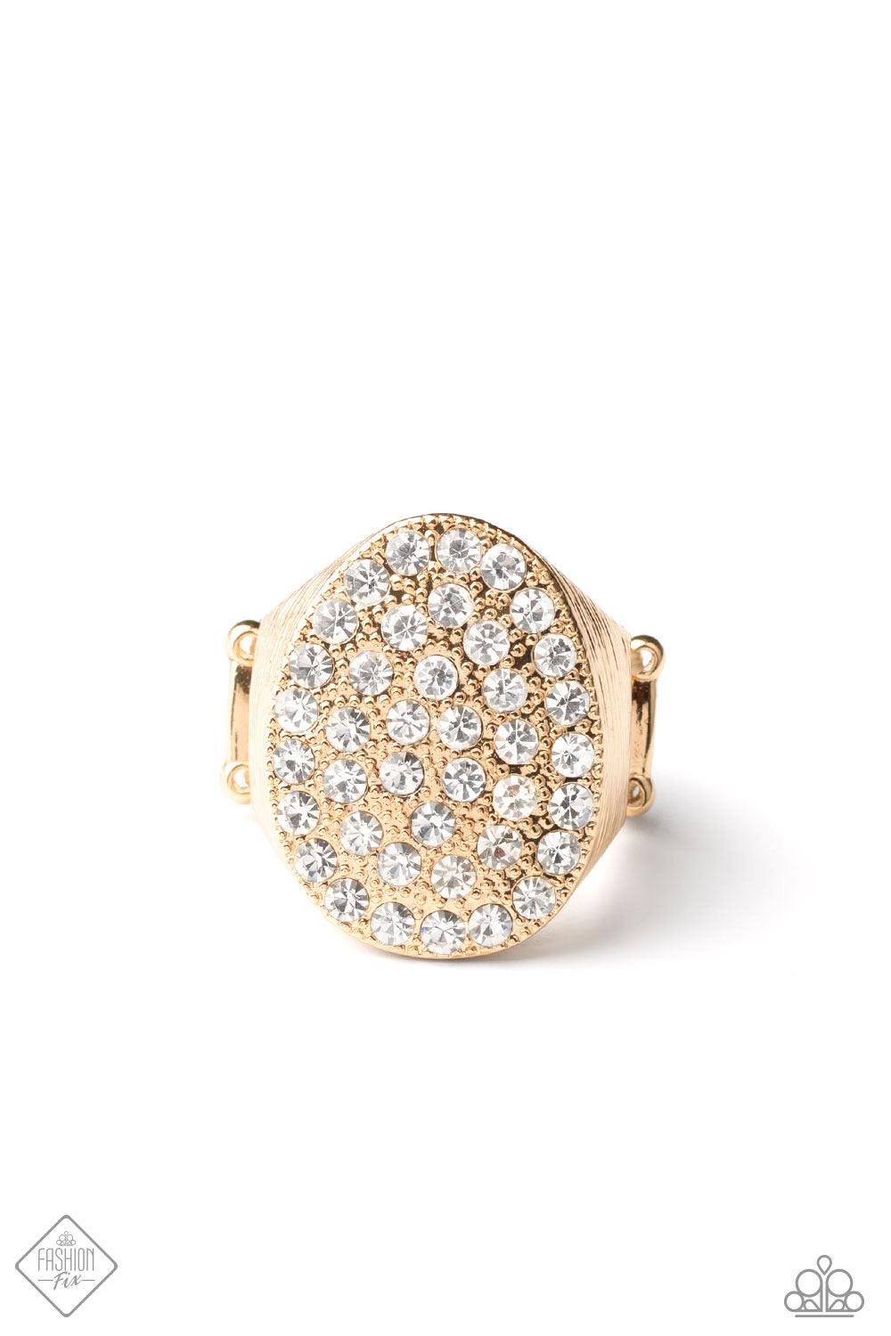 Paparazzi Accessories Test Your Luxe - Gold The front of a golden oval frame is haphazardly encrusted in a blinding scatter of glassy white rhinestones, creating a dramatic centerpiece atop the finger. Features a stretchy band for a flexible fit. Sold as