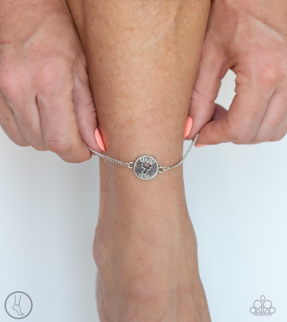 Paparazzi Accessories Summer Shade - Silver *Anklet Featuring an airy palm tree cutout and the words, "Beach Days", a shimmery silver charm attaches to a dainty silver chain around the ankle for a summery look. Features an adjustable clasp closure. Jewelr
