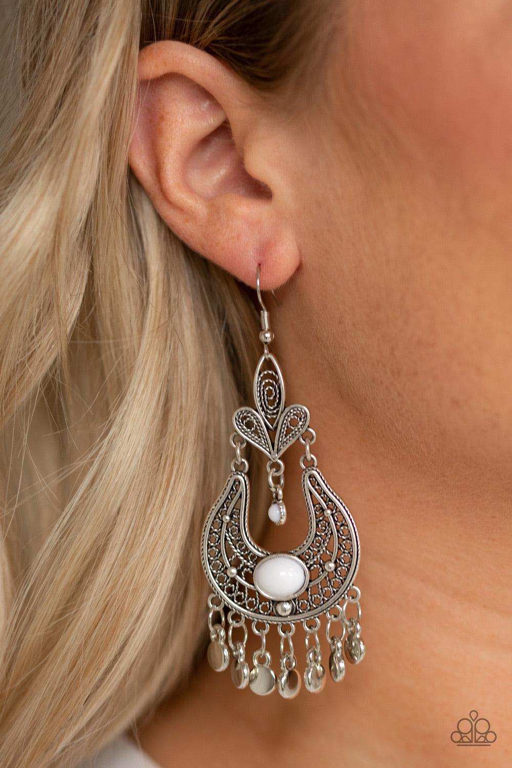 Paparazzi Accessories Fiesta Flair - White Swirling with vine-like filigree, ornate silver frames delicately link into a stacked frame. Infused with shiny white beads, the whimsical frame gives way to a fringe of glistening silver discs for a playful flai