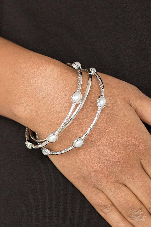 Paparazzi Accessories Bangle Belle - White Delicately hammered in shimmer, a pair of pearly white encrusted bangles joins a smooth silver bangle around the wrist for a refined fashion. Jewelry