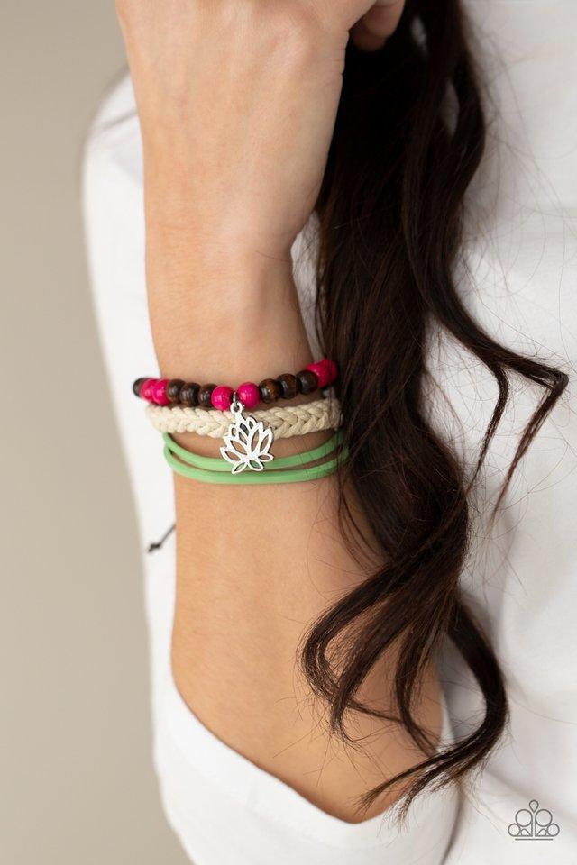 Paparazzi Accessories Lotus Beach - Pink Featuring a silver lotus charm, a strand of brown and pink wooden beads, braided white cording, and strands of Green Ash leather layer around the wrist for a seasonal flair. Features an adjustable sliding knot clos