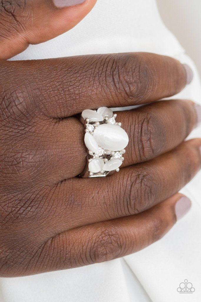 Paparazzi Accessories Modern Moonwalk - White Glittery white rhinestones and glowing white moonstones are sprinkled across the finger, coalescing into a whimsical band. Features a stretchy band for a flexible fit. Sold as one individual ring. Jewelry